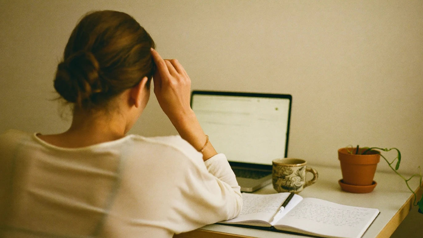 Multirow row 1 hero: woman at home office desk, body language of held tension